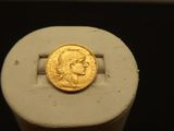 une image représentant une pièce d'or posée sur un socle blanc