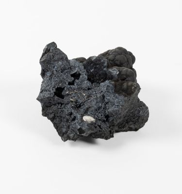 a piece of black rock that is on a white surface