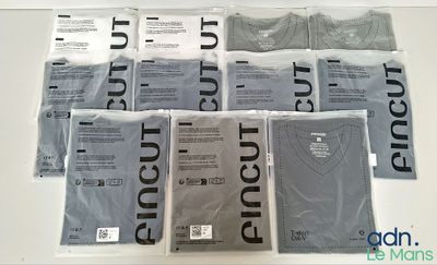 un grand nombre de t-shirts posés sur une table