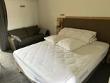 a bed with white sheets and pillows in a small room