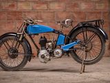 a blue motorcycle that is parked in front of a brick wall