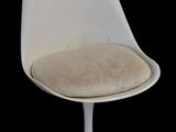 a white chair with a cushion on it on a black background