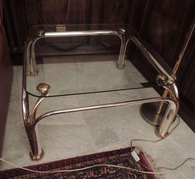 une table basse en verre avec un cadre en métal et un plateau en verre