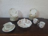 une table sur laquelle sont posés tout un tas d'assiettes, de tasses et de soucoupes