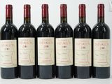 six bouteilles de vin rouge alignées sur une surface blanche