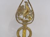 a golden bird on top of a brass object