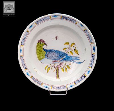 une assiette sur laquelle est peint un oiseau sur fond noir