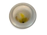 a glass cup with a yellow substance inside of it