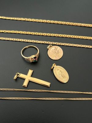 une collection de bijoux en or comprenant une croix, une pièce de monnaie et une bague