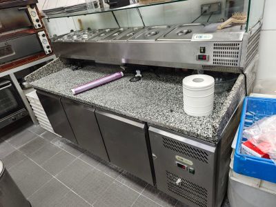 une photo d'une cuisine professionnelle équipée d'appareils électroménagers et de plans de travail en acier inoxydable