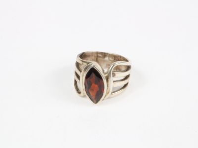une bague en argent avec une pierre rouge au centre
