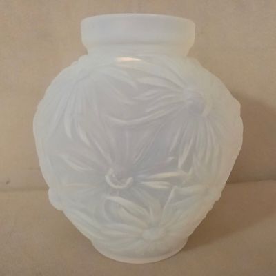 un vase en verre blanc orné d'un motif floral