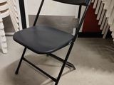 a black folding chair sitting in front of a radiator