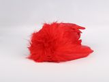 a red feather ball on a white surface