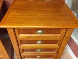 une paire de tables de chevet en bois avec des tiroirs et un miroir dans une chambre
