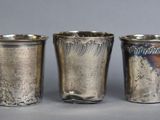 three silver cups sitting next to each other on a table