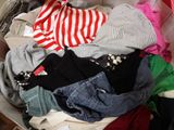 a suitcase full of clothes and clothes sitting on the floor