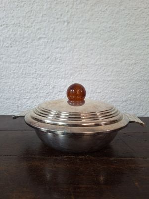 a metal bowl with a wooden ball on top of it