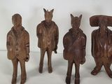 four wooden figurines of horses and a man in a suit and tie