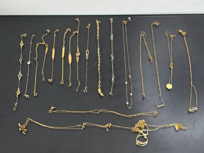 a group of gold necklaces and bracelets on a black surface