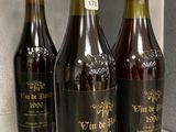 three bottles of wine sitting on a counter in a kitchen