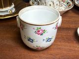 a cup and saucer sitting on a table next to a plate