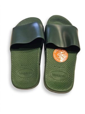 une paire de chaussons verts à semelles en caoutchouc noires sur fond blanc