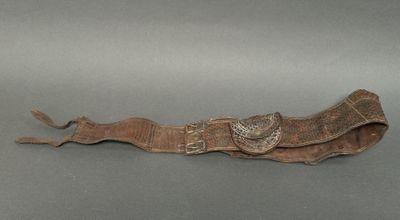 an old brown leather belt with a metal buckle and a butterfly on it