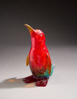un oiseau rouge perché sur une surface blanche