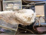 une boîte remplie d'objets divers, notamment un bonnet en fourrure, un sac à main et d'autres articles