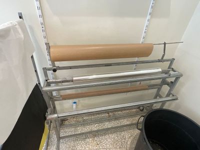 un support métallique sur lequel est posé un rouleau de papier