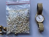 a bag of beads, a watch, and a chain on a table