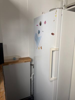 a refrigerator in the corner of a kitchen with a wooden counter top