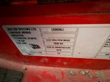 a close up of a red tractor seat with a sticker on it