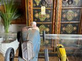 a small toy car sitting on a table next to a cabinet