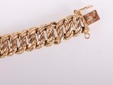 a close up of a gold chain bracelet on a white background