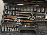 une caisse à outils avec des outils à l'intérieur sur le sol