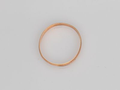 gros plan d'une bague en or sur une surface blanche