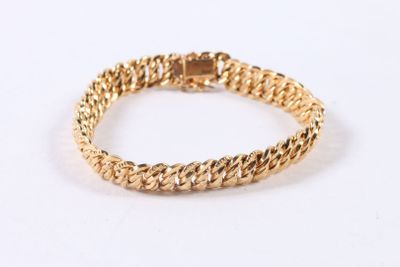 a close up of a gold bracelet on a white background