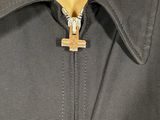 a close up of a person wearing a jacket with a cross on it