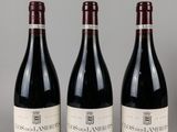 trois bouteilles de vin rouge sont alignées sur une table