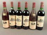 six bottles of wine are lined up on a table