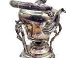 un vase en argent posé sur un socle, contenant une cuillère