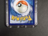 a pokemon card in a plastic case on a table