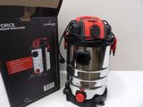 a silver and red vacuum on a table next to a box