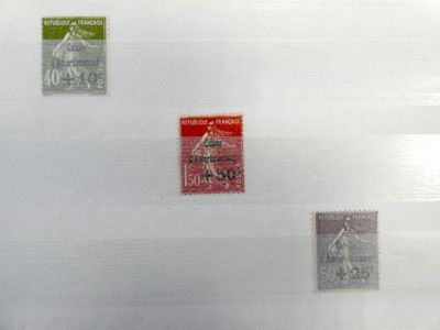quatre timbres différents posés sur une feuille de papier posée sur une table