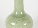 a green vase that is sitting on a white surface