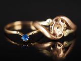 une image représentant une bague en or sertie d'une pierre bleue sur un fond noir