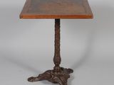une petite table avec un plateau en bois et des pieds sculptés