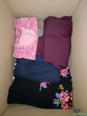 une boîte en carton remplie de vêtements et d'un oreiller